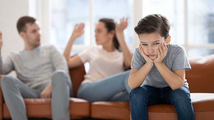 A unhappy boy with parents arguing about high conflict divorce case