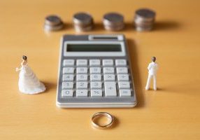 Image of divorce, money and troubles with calculator and ring.