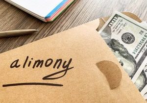 Payments alimony. White envelope with sign alimony and money.