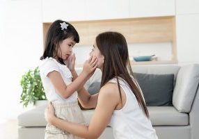 Asian family consoling together, mother and kids or little girl touch cheek and talking about soothe sad problem topic