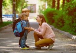 Back to school. Parent taking child to school. Pupil of primary school go study with backpack. Mom and daughter and son go hand in hand. Beginning of lessons.  First day of fall. Elementary student.